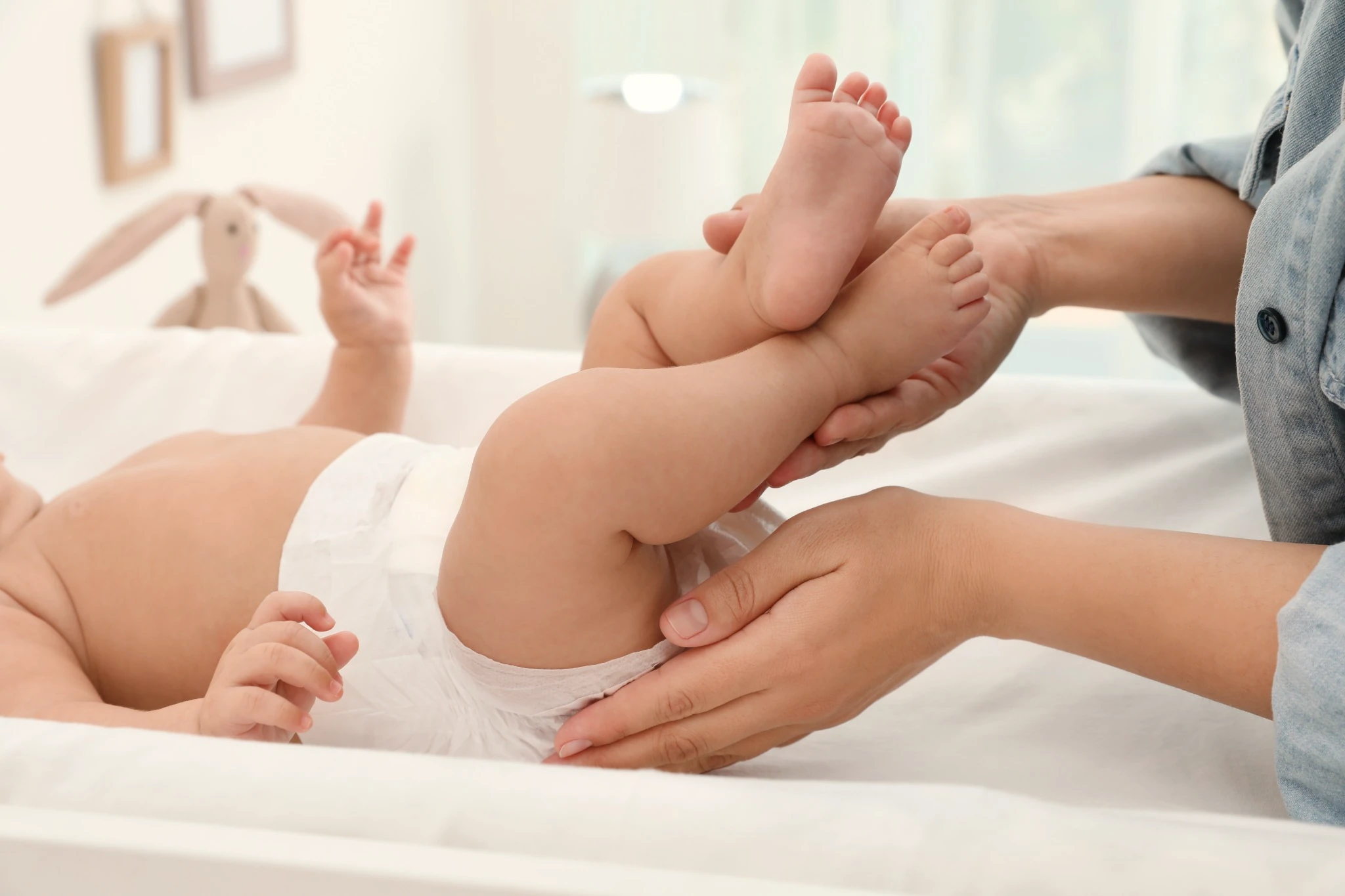 A real diaper change, held with calm hands